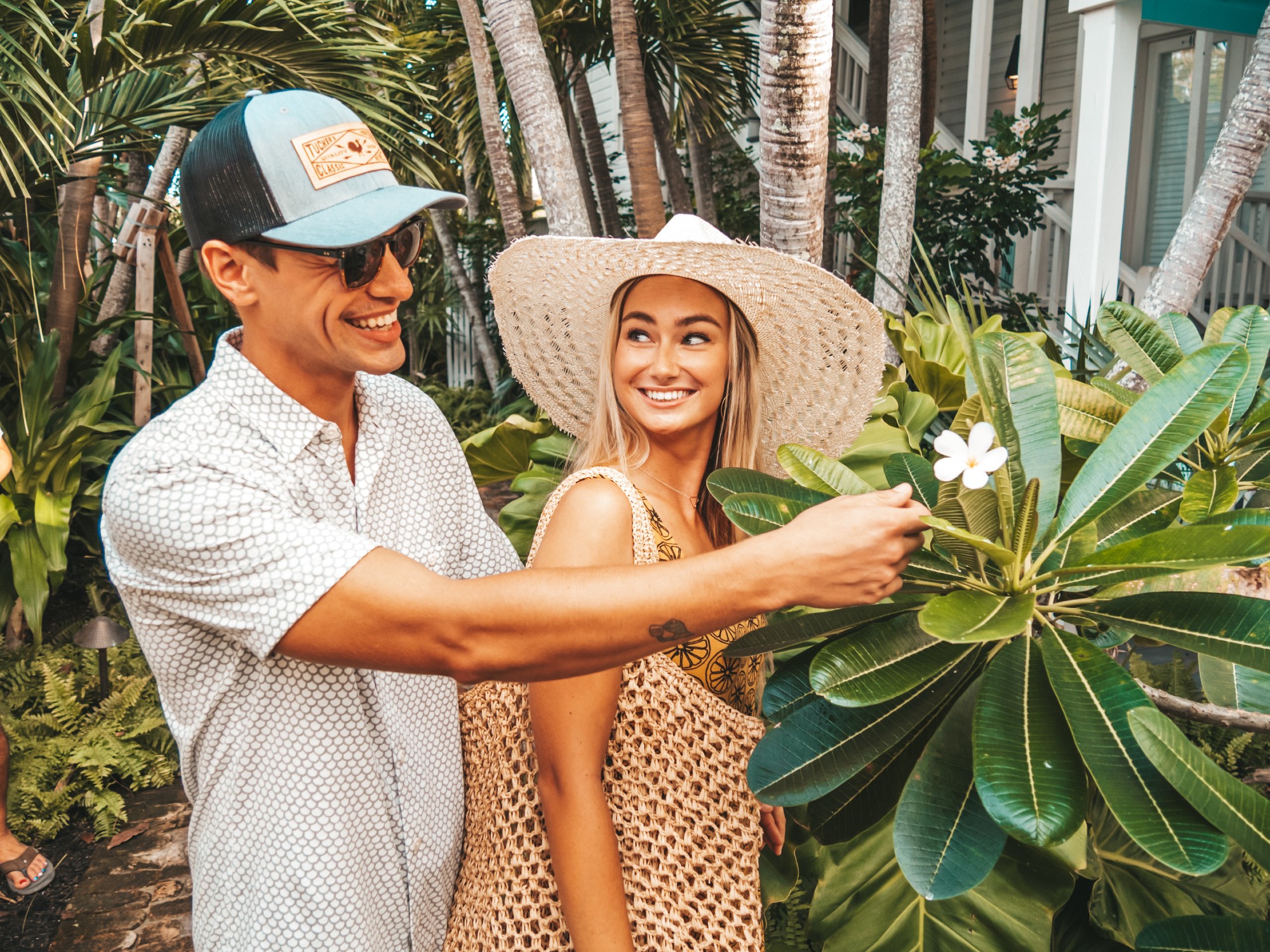 A young couple exploring Key West and looking at a flower